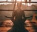 woman doing yoga meditation on brown parquet flooring