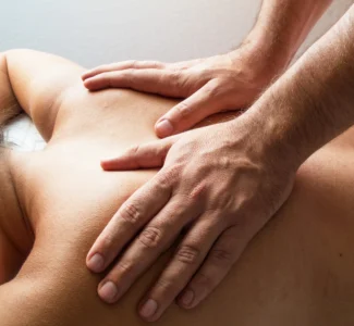 Person receiving a dry massage therapy session without oils.